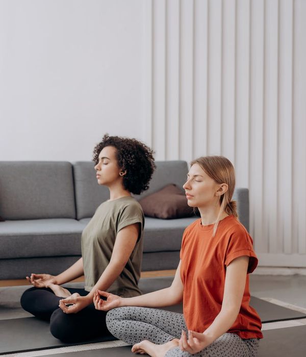Woman in a focused yoga pose in a bright, calm room.